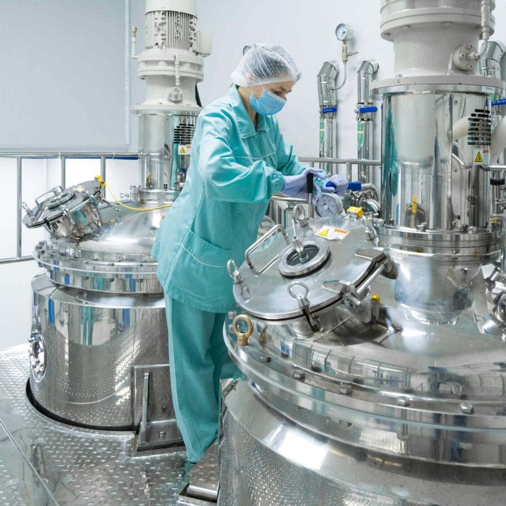 Technician working with stainless extraction vessels in the Pickering cleanroom